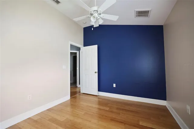 an empty room with closet and a ceiling fan