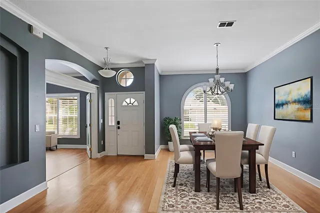 a view of a dining room with furniture a chandelier and wooden floor