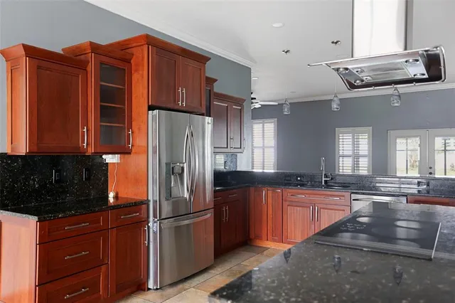 a kitchen with stainless steel appliances granite countertop a refrigerator and a sink