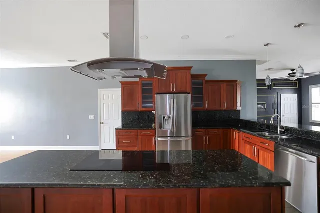 a kitchen with stainless steel appliances granite countertop a sink a stove and a microwave