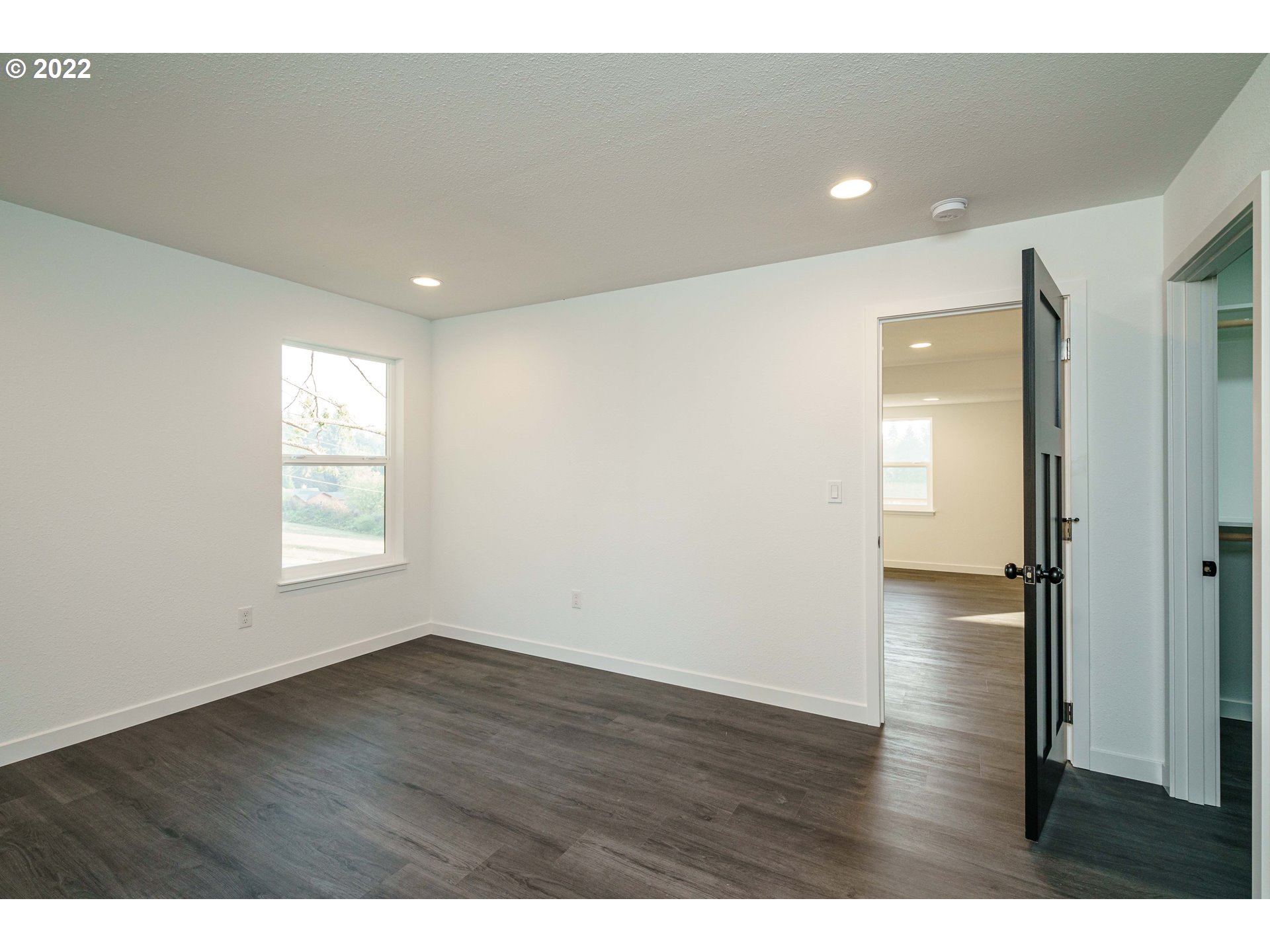 28371 Southeast KW Anderson Road Gresham, OR 97080 - Photo 14 of 32 a view of an empty room with wooden floor and a window