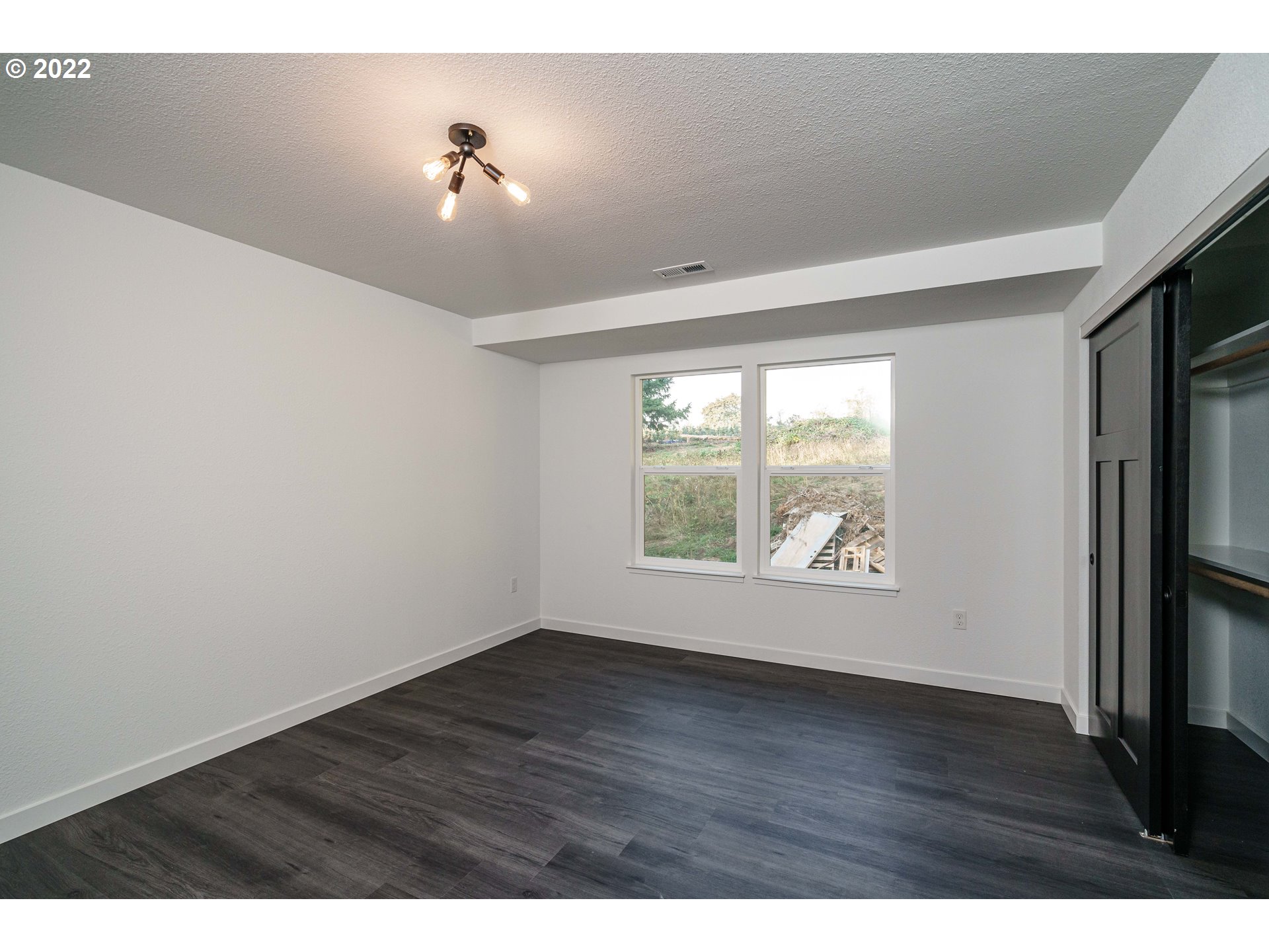 28371 Southeast KW Anderson Road Gresham, OR 97080 - Photo 17 of 32 a view of an empty room with wooden floor and a window