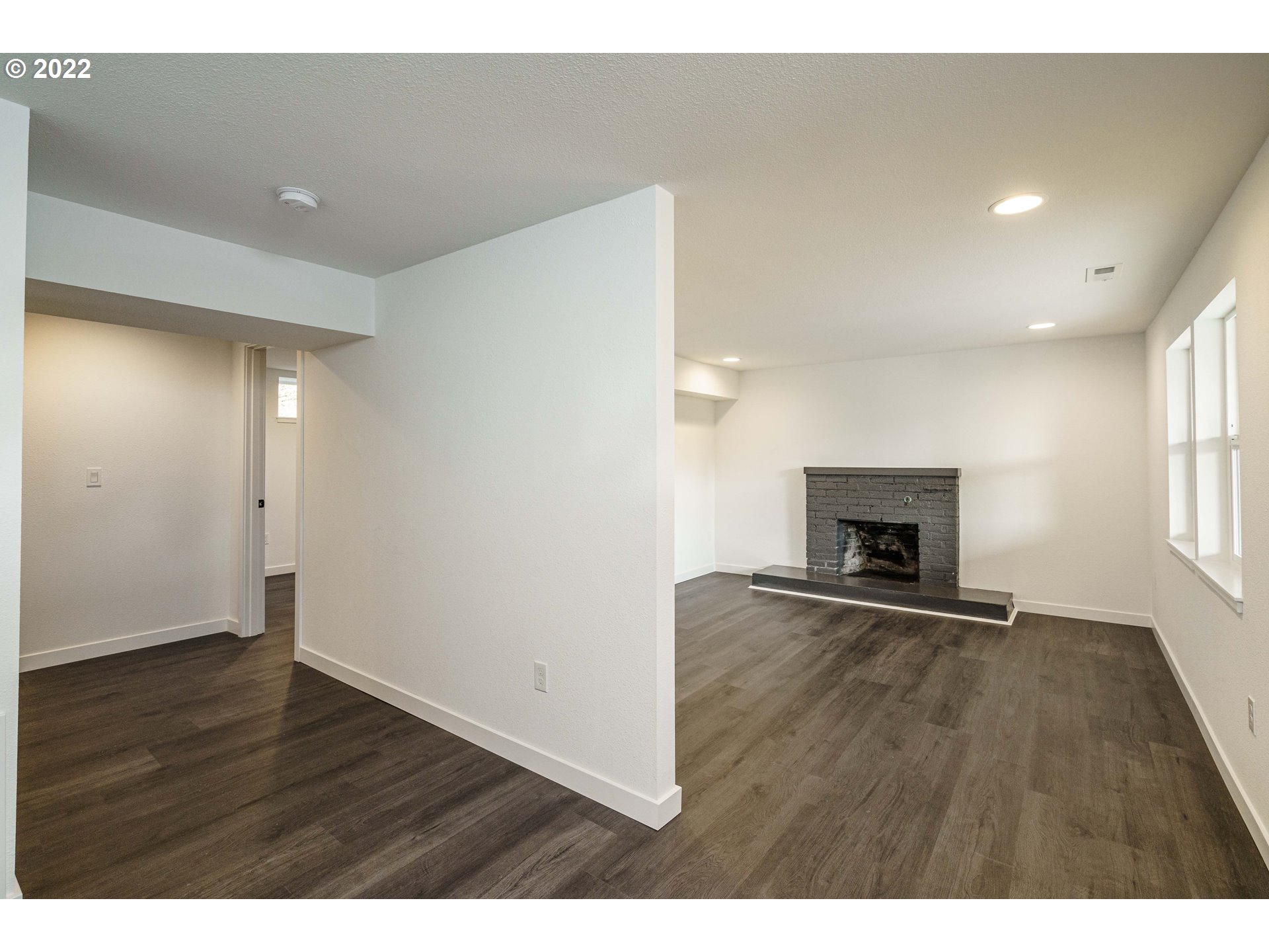 28371 Southeast KW Anderson Road Gresham, OR 97080 - Photo 6 of 32 a view of an empty room with wooden floor and a fireplace