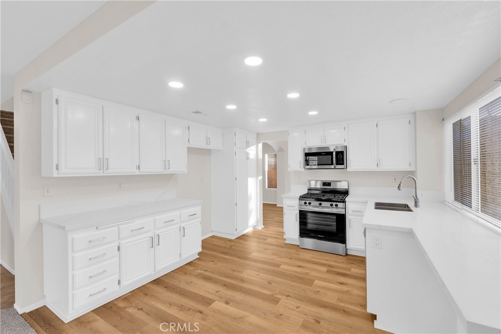 9253 Sunridge Drive Riverside, CA 92508 - Photo 13 of 54 a large kitchen with cabinets stainless steel appliances and a window