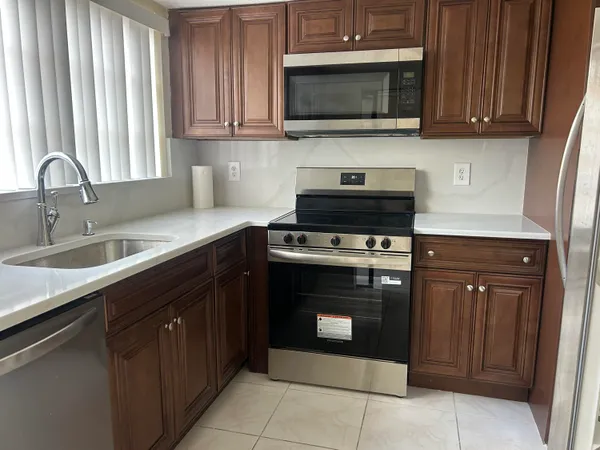 a kitchen with stainless steel appliances granite countertop a sink stove and microwave