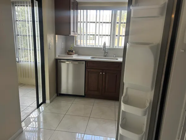a kitchen with a sink a refrigerator and window
