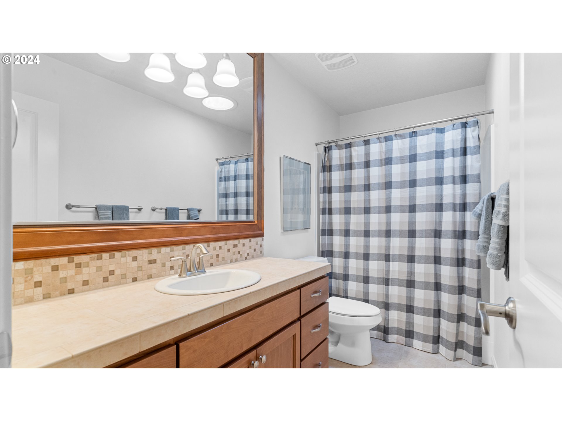 4511 Oakridge Road Lake Oswego, OR 97035 - Photo 19 of 44 a bathroom with a sink a toilet a mirror and shower curtain