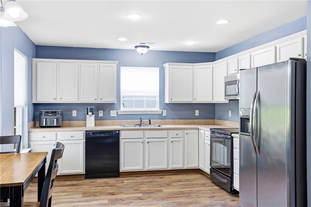 105 Lacy Lane Anderson, SC 29621 - Photo 8 of 16 Culinary adventures await in this kitchen featuring abundant white cabinetry and wood-look flooring.