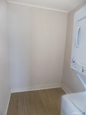 a view of a hallway with wooden floor and closet