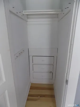 an empty room with wooden floor and closet