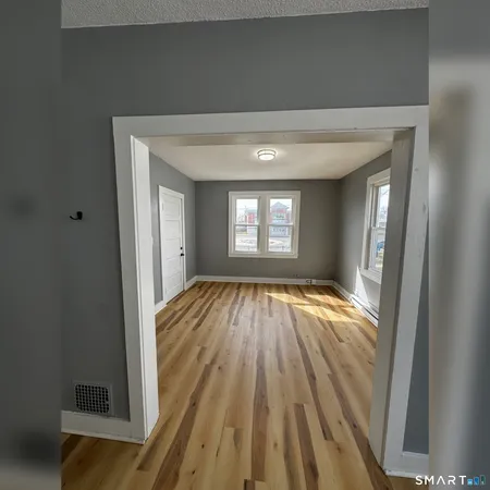 an empty room with wooden floor and closet