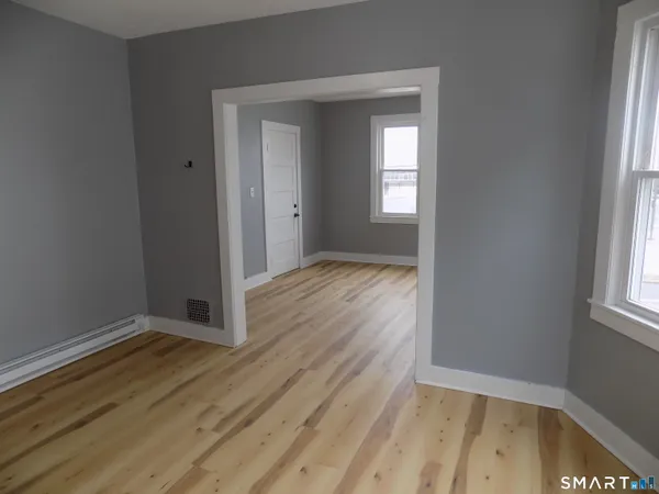 a view of an empty room with cabinet and a window
