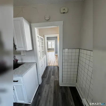 a view of hallway with window and wooden floor