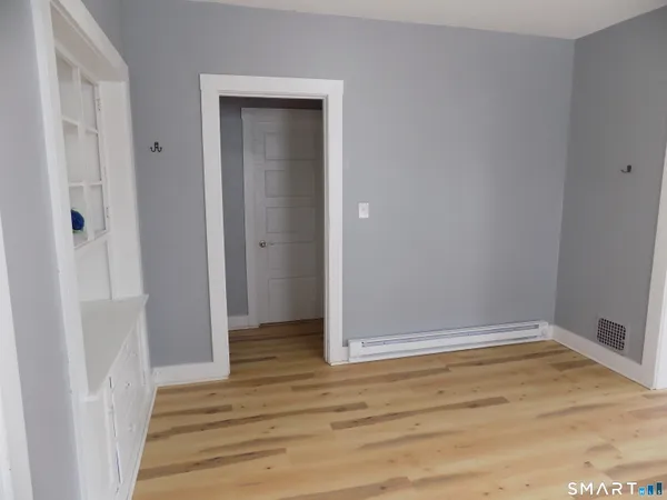 a view of hallway with window and wooden floor