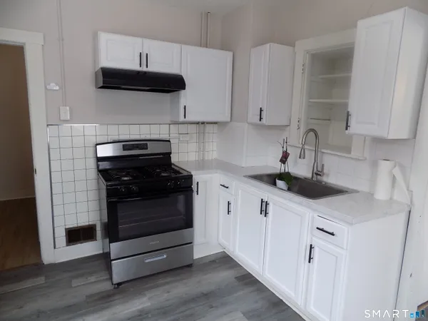 a kitchen with stainless steel appliances a sink dishwasher a refrigerator and cabinets