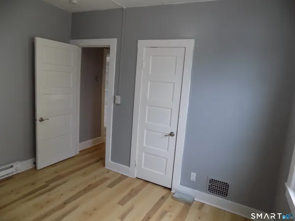 an empty room with wooden floor and closet