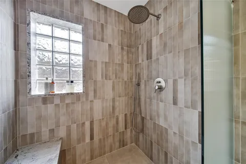 a bed sitting in a spacious bedroom next to a window