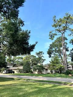 a front view of a house with a garden and trees