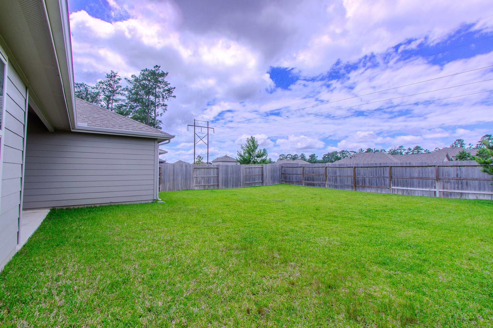 3113 Catalonion Court Conroe, TX 77301 - Photo 28 of 45 a view of a backyard with a large tree