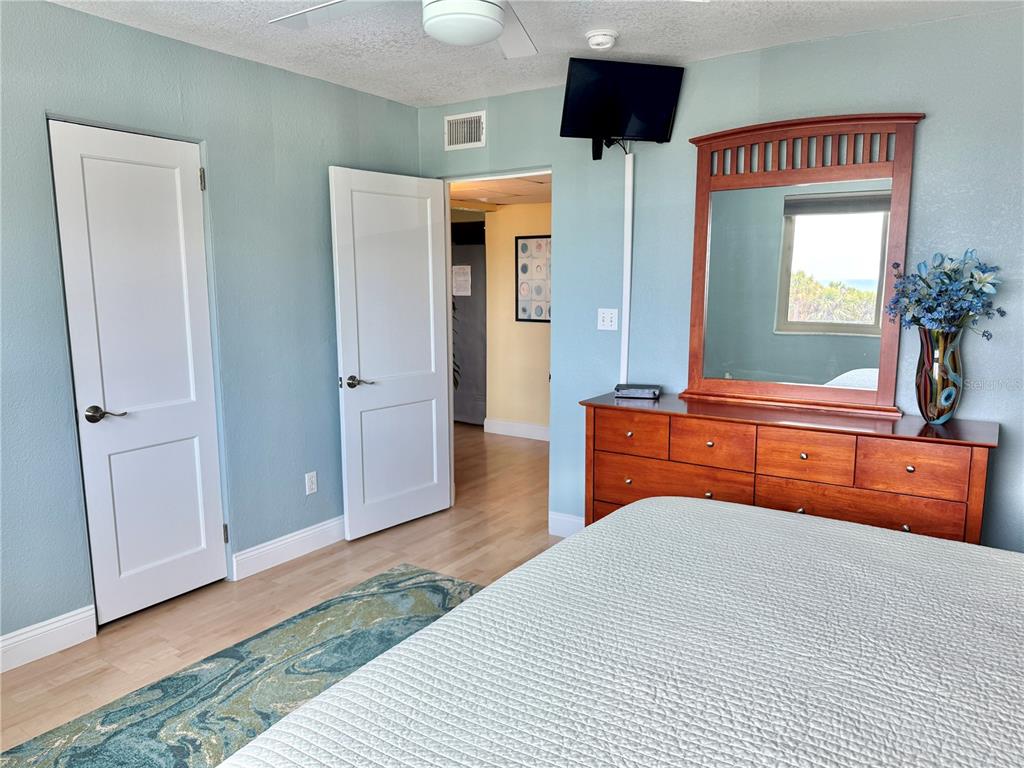 6700 Sunset Way, Unit 206 St. Pete Beach, FL 33706 - Photo 14 of 24 a bedroom with a bed and a chandelier