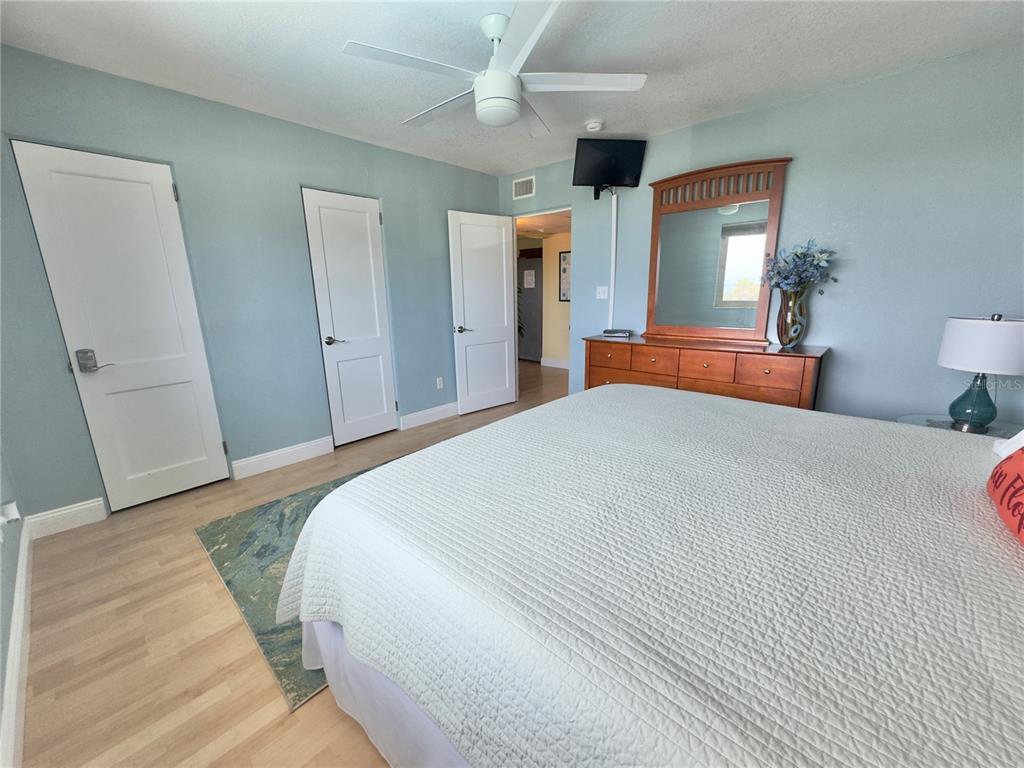 6700 Sunset Way, Unit 206 St. Pete Beach, FL 33706 - Photo 19 of 24 a bedroom with a bed and wooden floor