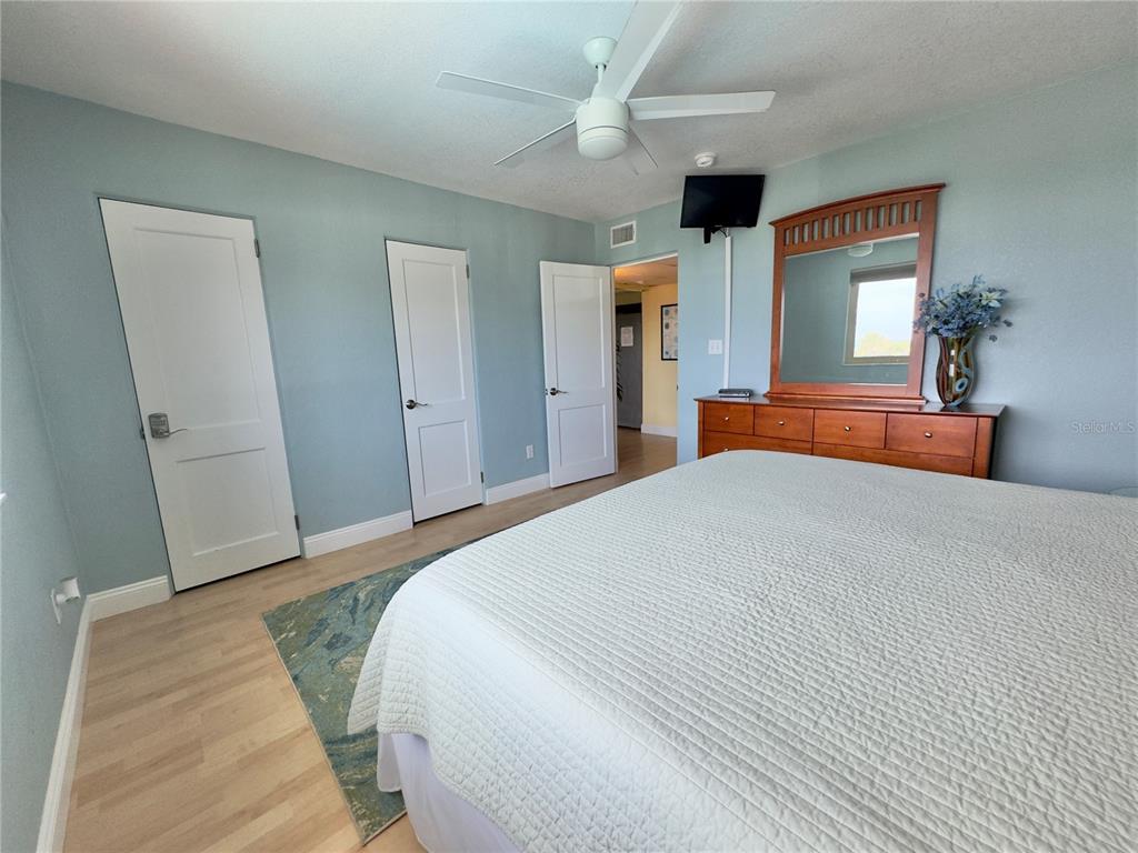 6700 Sunset Way, Unit 206 St. Pete Beach, FL 33706 - Photo 20 of 24 a bedroom with a large bed and a chandelier