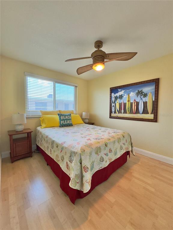 6700 Sunset Way, Unit 206 St. Pete Beach, FL 33706 - Photo 22 of 24 a bedroom with a bed and a chandelier