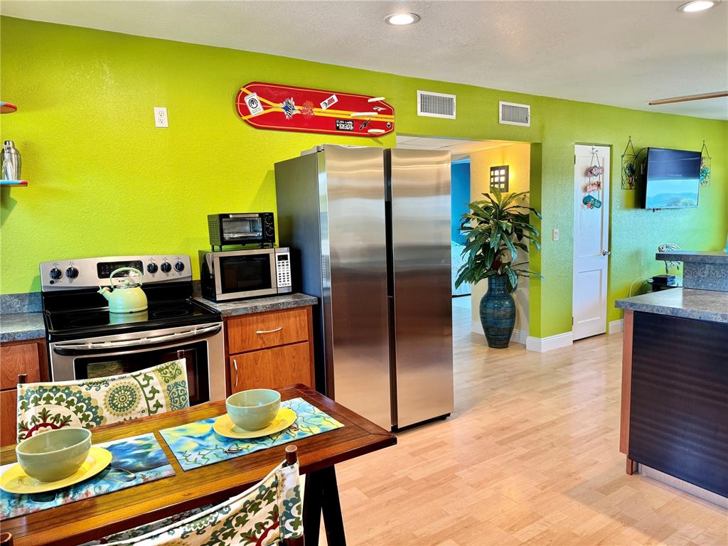 6700 Sunset Way, Unit 206 St. Pete Beach, FL 33706 - Photo 8 of 24 a kitchen with stainless steel appliances granite countertop a refrigerator and a stove top oven