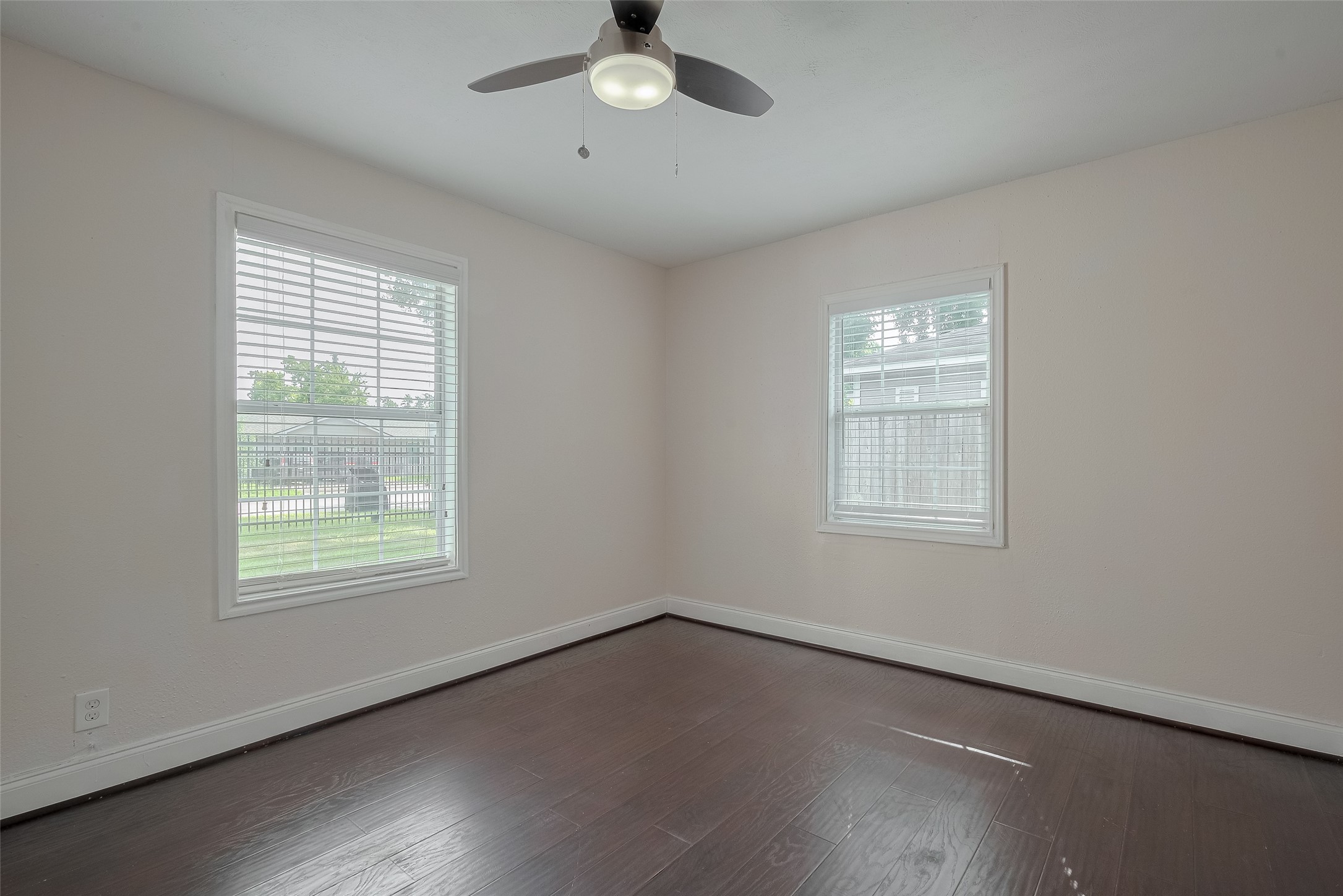 3930 Daphne Street Houston, TX 77021 - Photo 25 of 44 A generous footprint, soft neutral palette, and large windows make this bedroom a serene retreat. The rich flooring and ceiling fan offer both contrast and comfort.