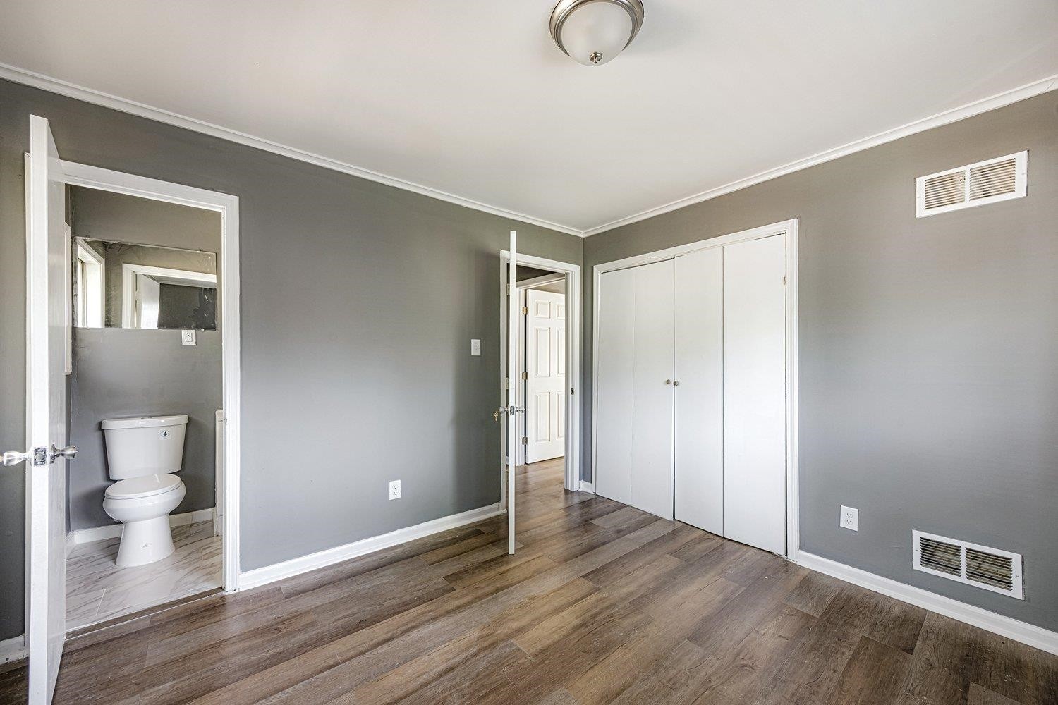 4025 Bishops Bridge Road Memphis, TN 38118 - Photo 11 of 18 a view of an empty room and a bathroom with wooden floor
