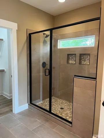 a bathroom with a glass shower door and mirror