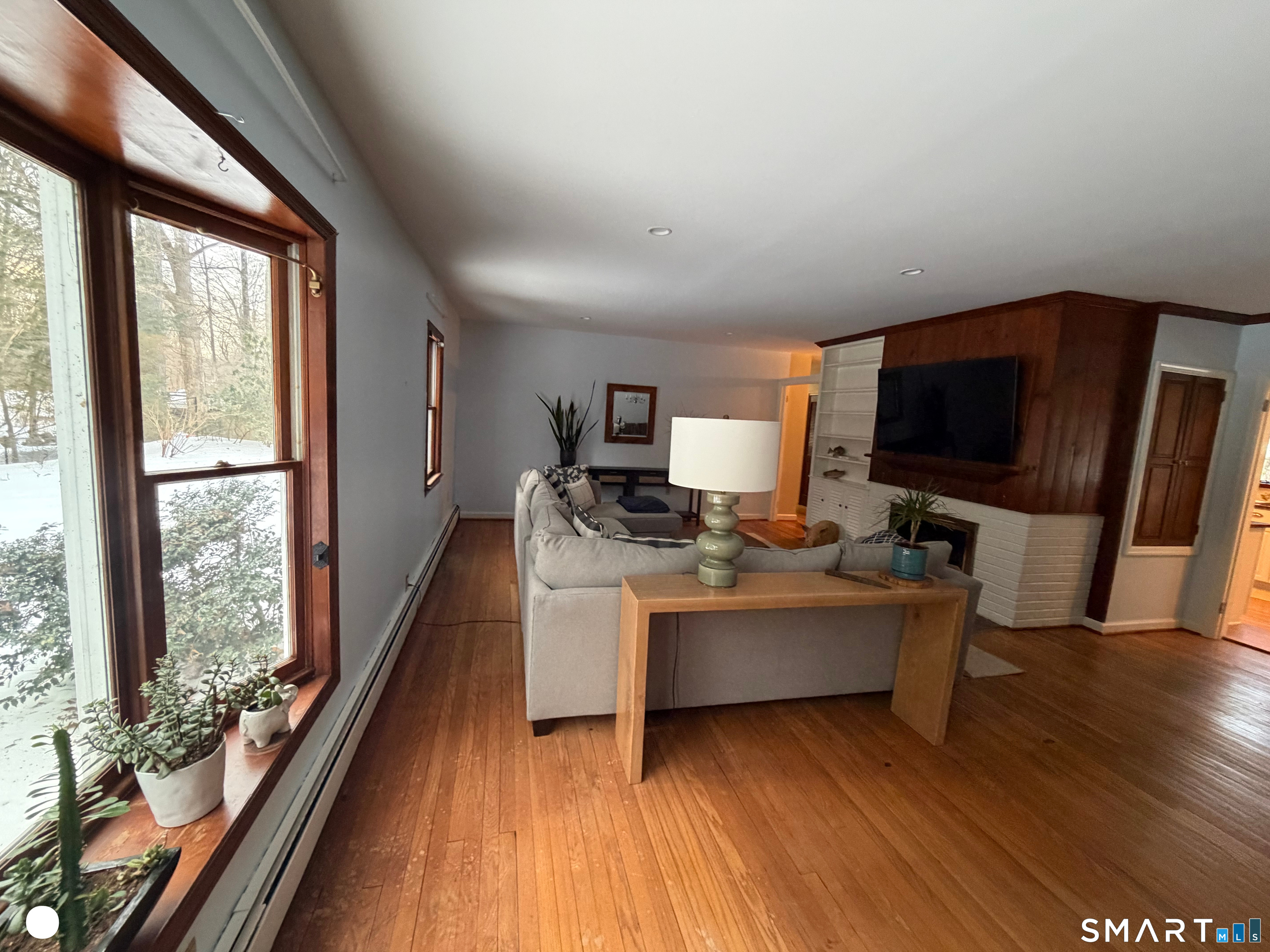 20 Arrowhead Road Wilton, CT 06897 - Photo 9 of 28 a living room with a flat screen tv and a floor to ceiling window