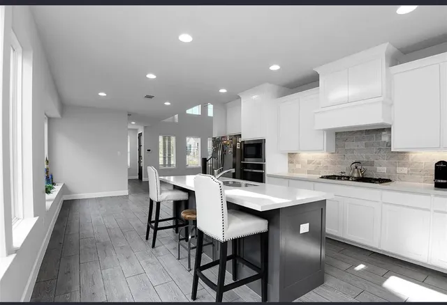 a kitchen with a dining table chairs and white cabinets