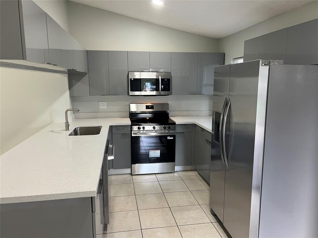 500 Northeast 34th Street Pompano Beach, FL 33064 - Photo 11 of 29 a kitchen with stainless steel appliances a refrigerator sink and microwave