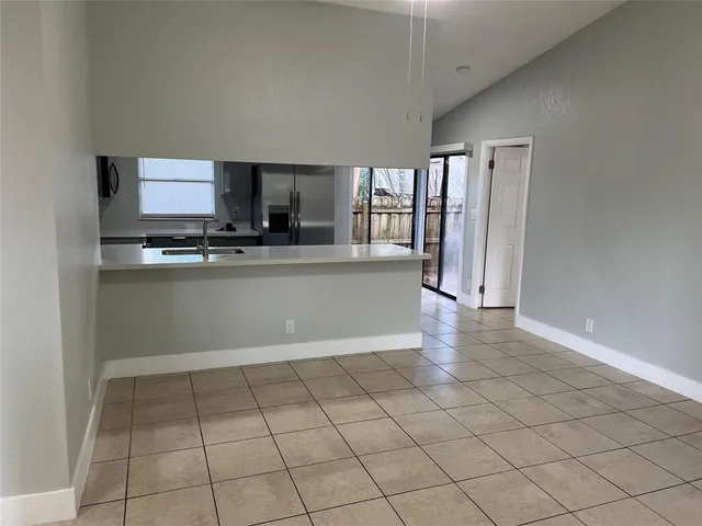 a large kitchen with a sink stainless steel appliances and a counter top space