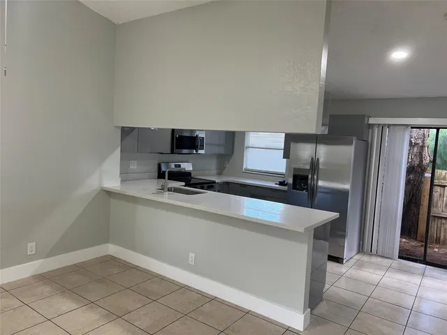 a kitchen with stainless steel appliances a refrigerator sink and microwave