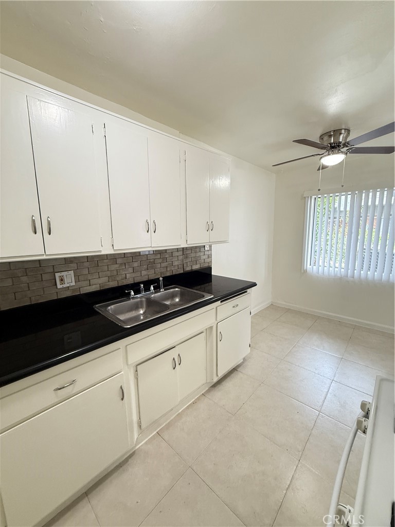 1168 North Mayfair Avenue, Unit 3 Anaheim, CA 92801 - Photo 2 of 10 a kitchen with stainless steel appliances white cabinets and sink