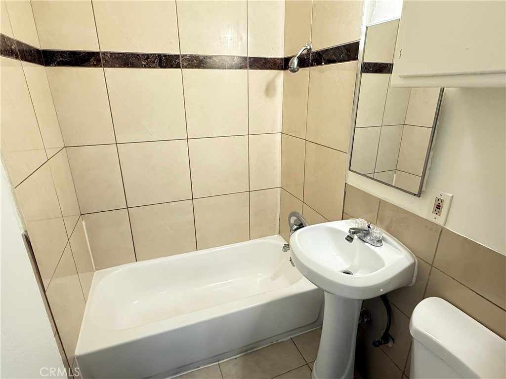 1168 North Mayfair Avenue, Unit 3 Anaheim, CA 92801 - Photo 6 of 10 a bathroom with a sink toilet and shower