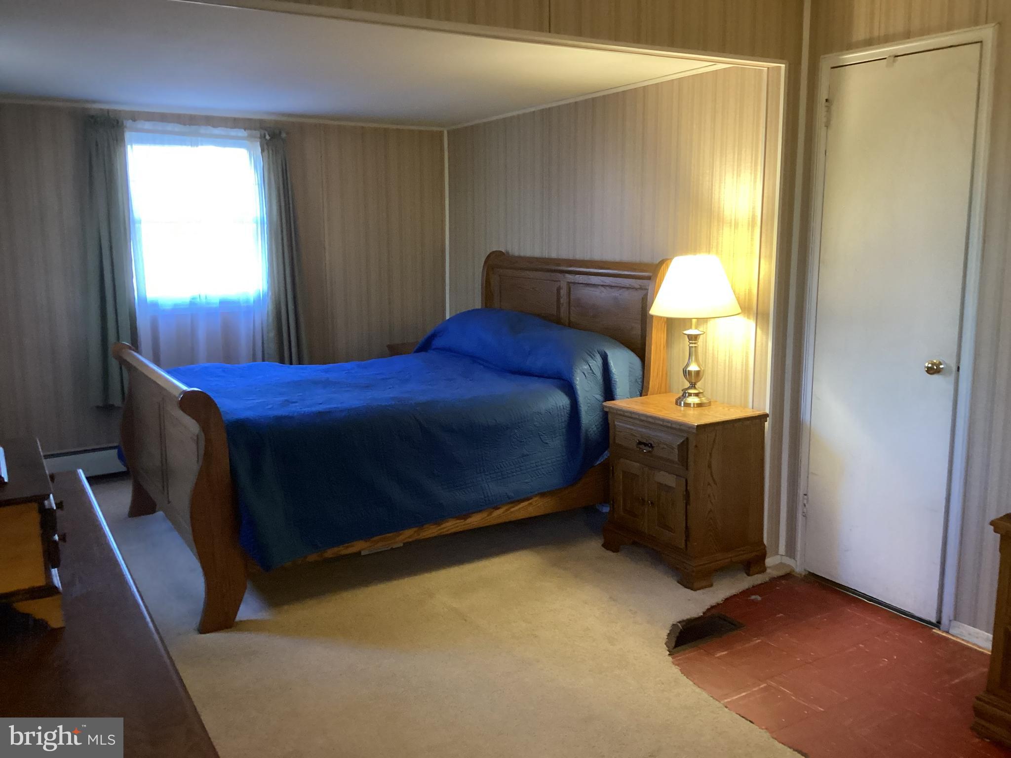 606 Fairhill Road Morrisville, PA 19067 - Photo 14 of 36 a bedroom with a bed and a lamp on dresser