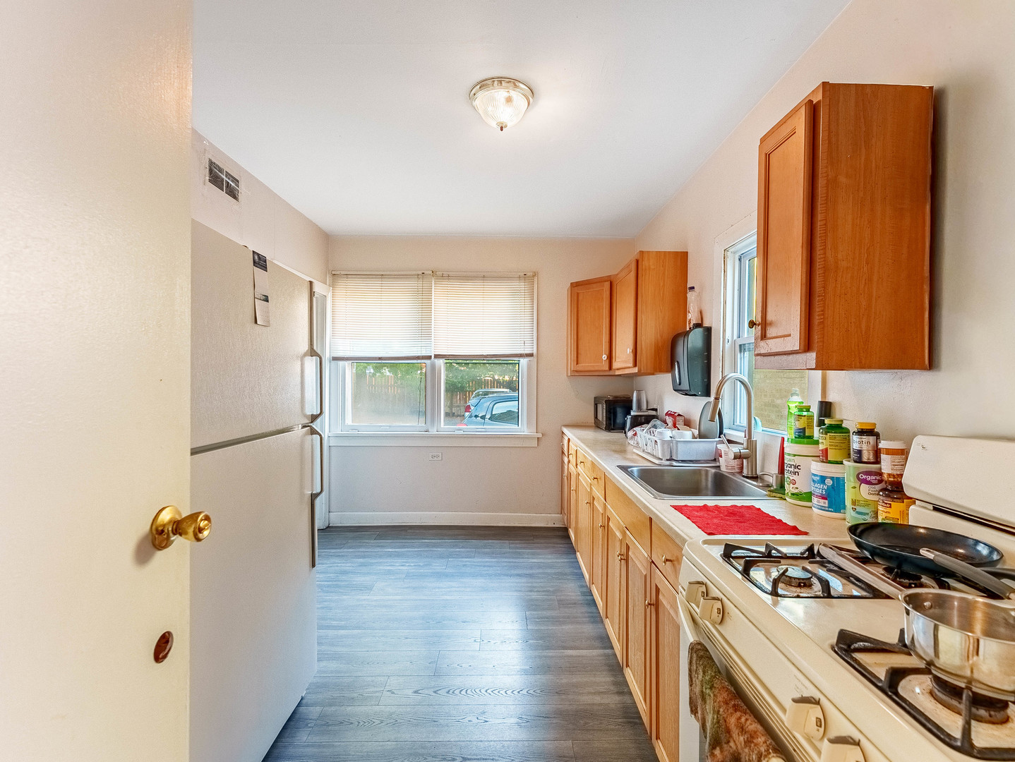 1014 Washington Street Waukegan, IL 60085 - Photo 7 of 18 a kitchen with a refrigerator a stove a sink dishwasher and wooden cabinets with wooden floor