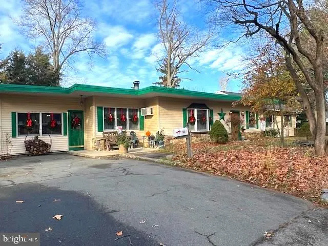 a view of a house with a large tree and wooden fence
