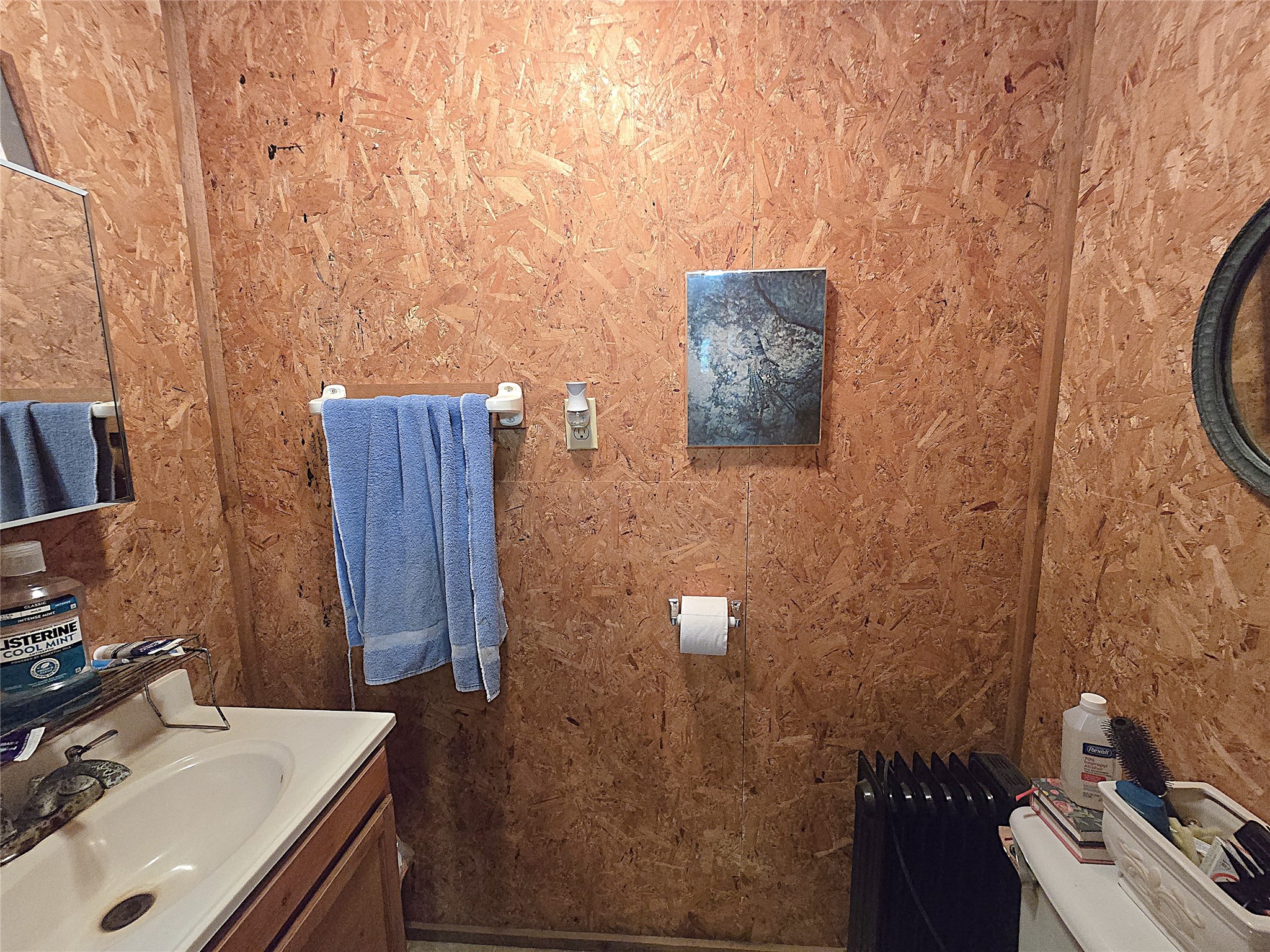 4499 Weaver Bend Road Huntington, TX 75949 - Photo 13 of 19 Cozy and functional half bath featuring rustic wood paneling, a practical vanity, and essential amenities for convenience and style.