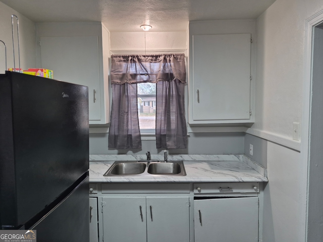 2241 Bruce Avenue Columbus, GA 31903 - Photo 9 of 15 a kitchen with a sink and a refrigerator
