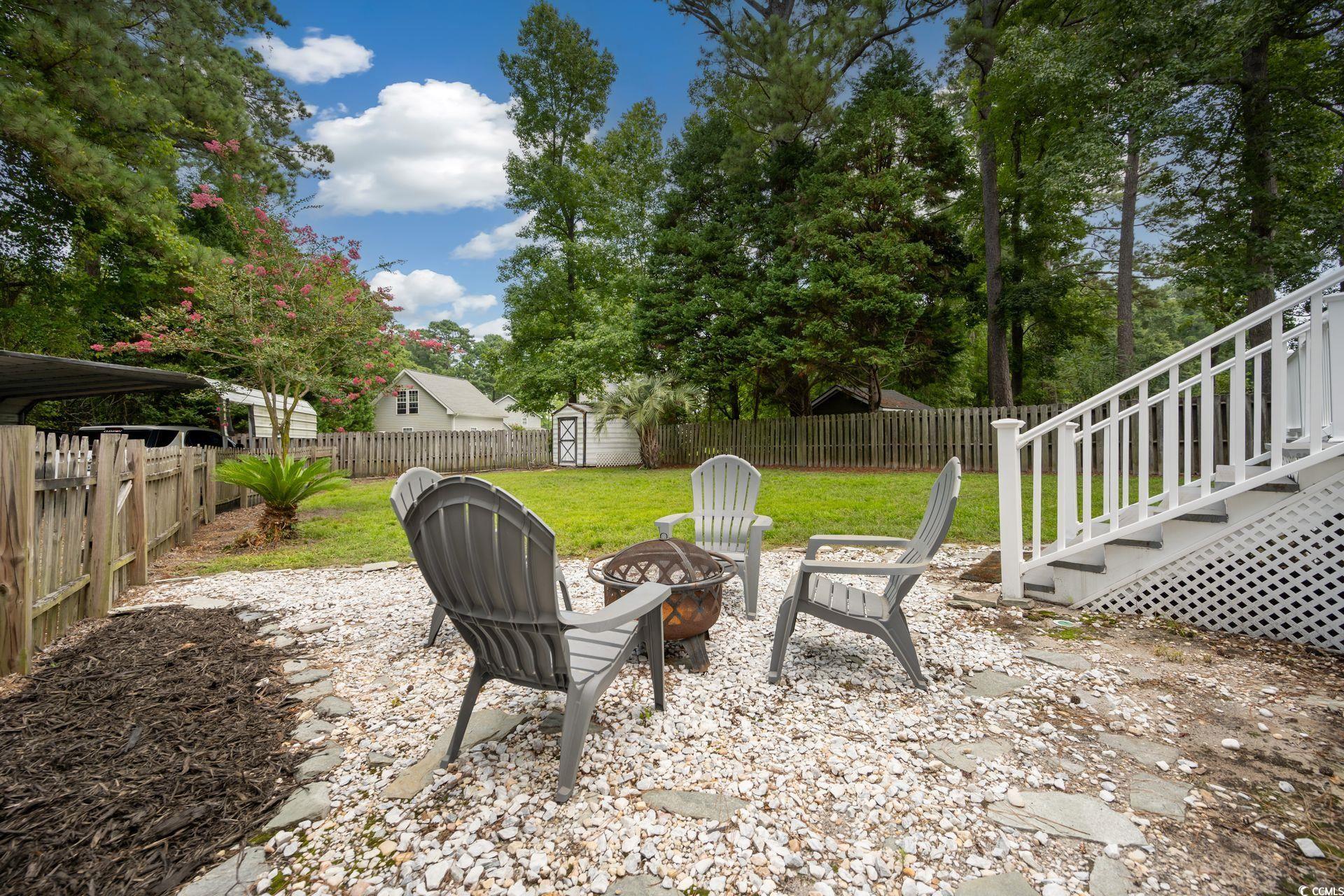 33 Great Lakes Road Pawleys Island, SC 29585 - Photo 25 of 30 View of yard featuring a fire pit and a shed