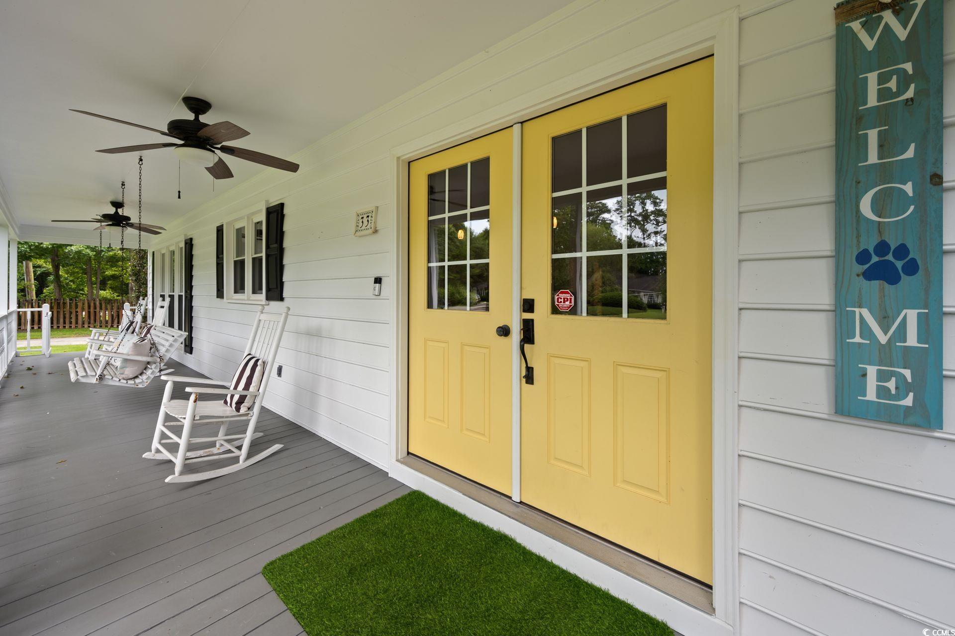 33 Great Lakes Road Pawleys Island, SC 29585 - Photo 4 of 30 View of exterior entry with ceiling fan and covere