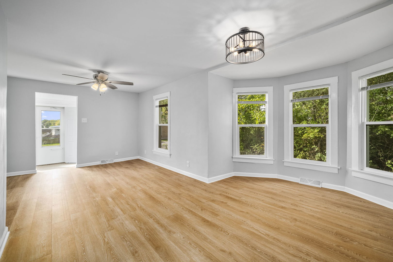 303 Princeton Street Lockport, IL 60441 - Photo 6 of 16 a view of an empty room with a window and wooden floor