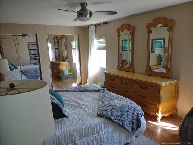 a bedroom with a bed a mirror and dresser