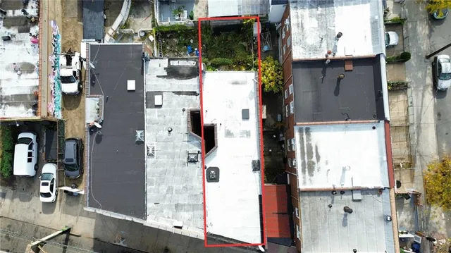 an aerial view of residential houses with outdoor space and parking