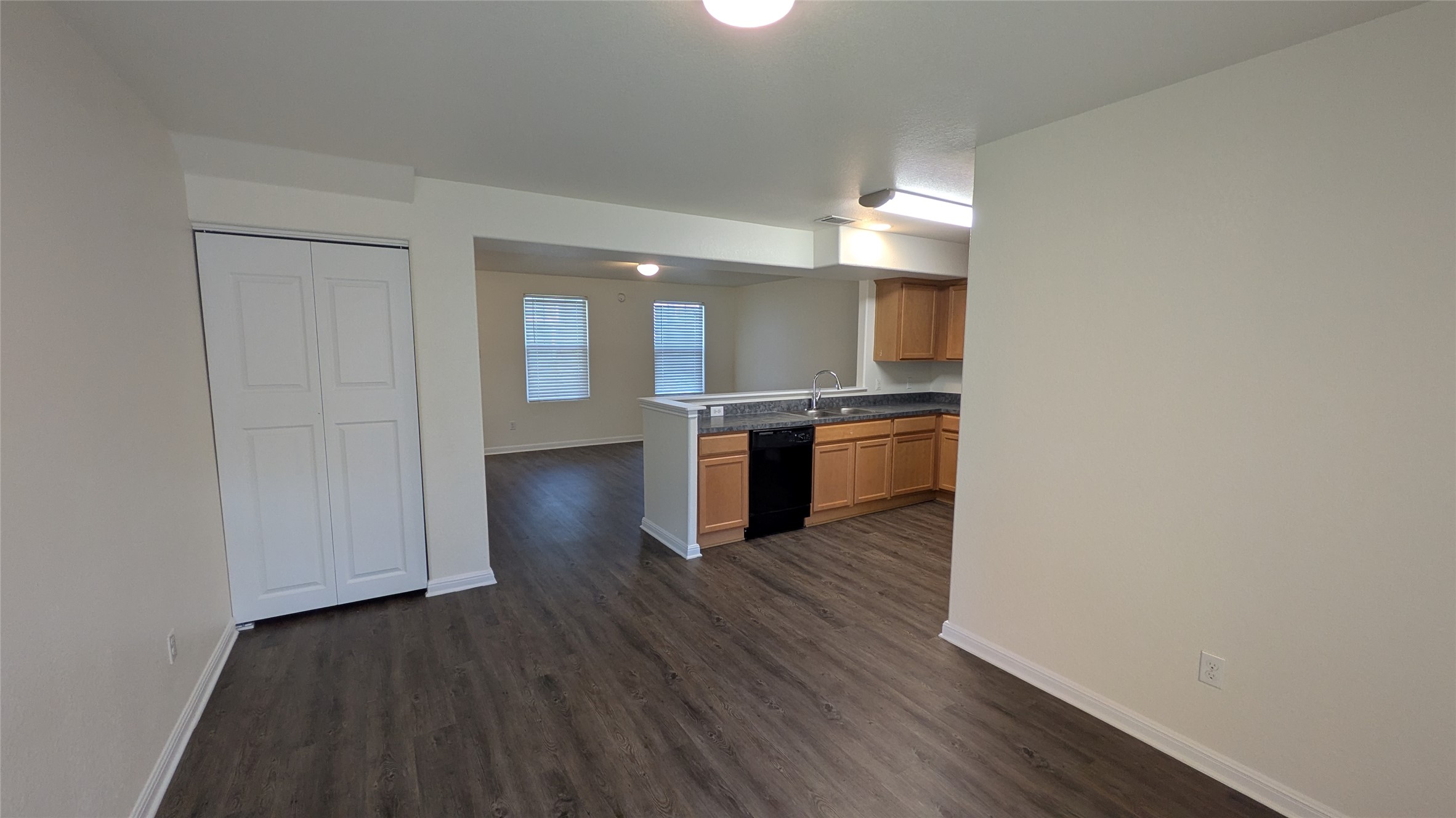 262 Trestle Tree San Marcos, TX 78666 - Photo 6 of 18 an empty room with wooden floor kitchen view and windows