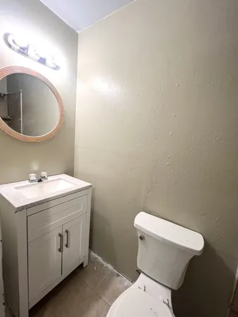 a bathroom with a toilet sink and mirror